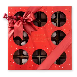 Deluxe holiday chocolate box with festive red ribbon and berry decoration, featuring assorted chocolates and truffles from Harem Chocolate, perfect for gift-giving during festivities.