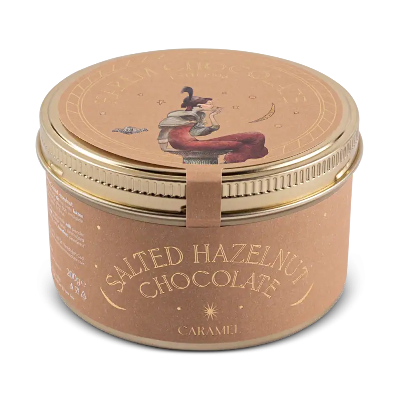 Cream-colored metal tin with artistic illustration of a woman reading, labeled "Salted Hazelnut Chocolate - Caramel" from Shop of Turkey, emphasizing authentic Turkish sweets with fast shipping.