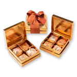 Chocolate candies in elegant gold gift boxes, perfect for gifting.