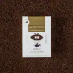 Rich dark brown ground cacao chocolate bar with handmade illustrations, enhanced with cardamom and kakule flavors, sourced from Ghana for premium quality.