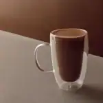 Creamy hot chocolate served in a double-walled glass mug, showcasing elegant presentation and rich flavor. Perfect for cozy moments or gifting from Turkey's authentic shop.