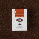 Rich dark chocolate bar on a bed of finely ground cocoa powder, showcasing premium quality and natural ingredients for a luxurious indulgence.