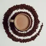 1. A cup of Turkish hot cocoa surrounded by cocoa powder in a swirl pattern, showcasing traditional Turkish beverage.