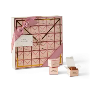 Deluxe pink and gold pastry box with Harem Chocolate treats, elegant ribbon, and individual chocolates, perfect for gifting or special occasions.