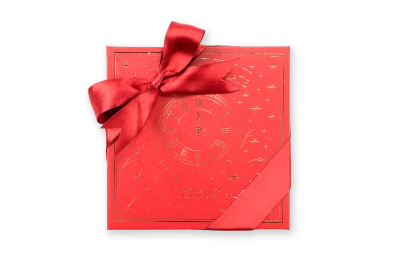 Elegant red gift box with a satin ribbon and gold clock design, perfect for New Year celebrations and holiday gifting from Turkey.