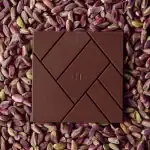 Smooth milk chocolate bar on pistachio nuts, luxurious confectionery, premium quality, handcrafted, Turkish chocolate, sweet, delicious, snack, gourmet treat, artisanal chocolate, rich flavor.
