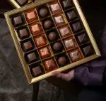 Rich assortment of luxurious Turkish chocolates in a gold gift box, featuring assorted pralines and truffles, perfect for gifting or indulgence.