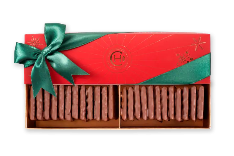 Delicious chocolate-covered biscuits in festive holiday packaging with a green ribbon, perfect for Christmas gifts or celebrations.