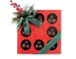 Delicious assorted Turkish chocolates in a festive red gift box with a green satin ribbon and holiday decoration, perfect for Christmas or special occasions.