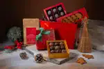 Delicious assorted chocolates and Turkish treats in festive gift boxes with holiday decorations and pinecones, perfect for Christmas gifts from Turkey.