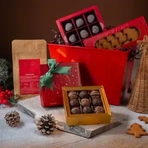 Delicious assorted chocolates and Turkish treats in festive gift boxes with holiday decorations and pinecones, perfect for Christmas gifts from Turkey.