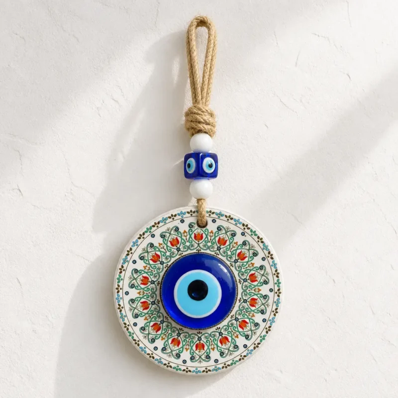 Evil eye wall hanging with jute cord and blue glass beads displayed indoors