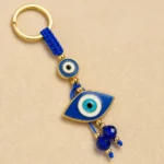 Turkish evil eye keychain laid flat on a neutral surface with beads spread
