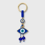 Turkish evil eye keychain with blue macramé cord held in palm