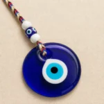Turkish evil eye nazar with braided cord and glass beads on dark background