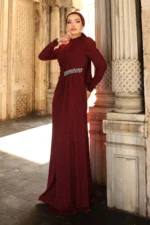 Glimmette hijab evening dress in burgundy glitter fabric with stone-embellished waist and long sleeves