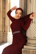 Glimmette hijab evening dress in burgundy with glitter fabric and stone-embellished waist belt