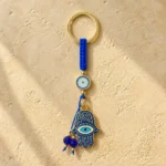 Blue macramé hamsa keychain hanging from a bag strap