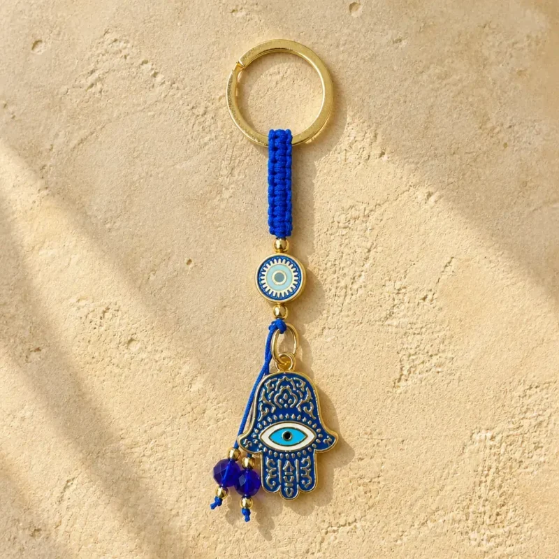 Blue macramé hamsa keychain hanging from a bag strap