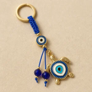 Turkish evil eye sea turtle keychain on dark background with gold ring