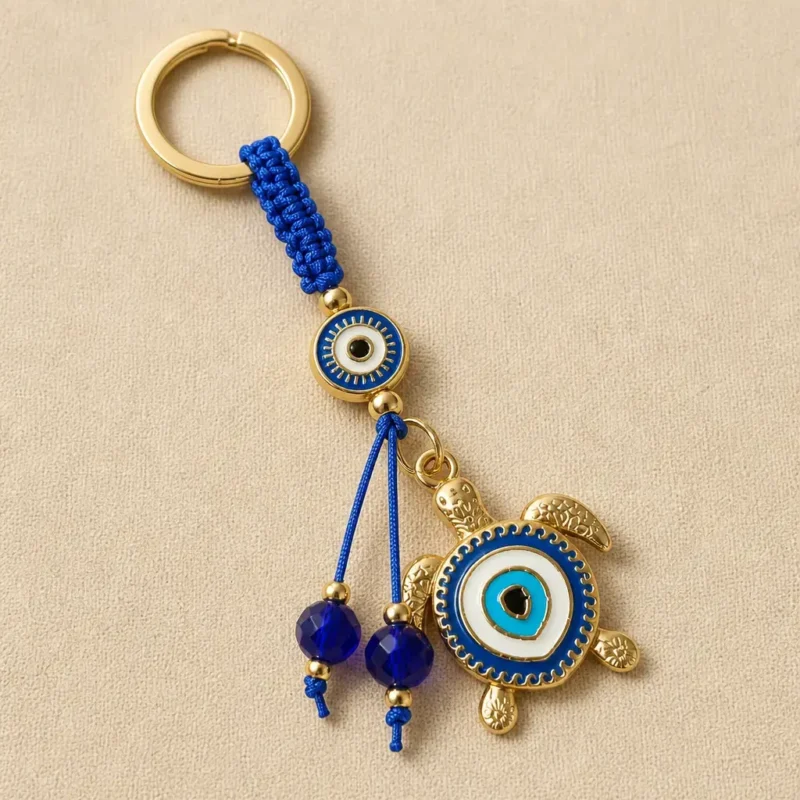 Turkish evil eye sea turtle keychain on dark background with gold ring